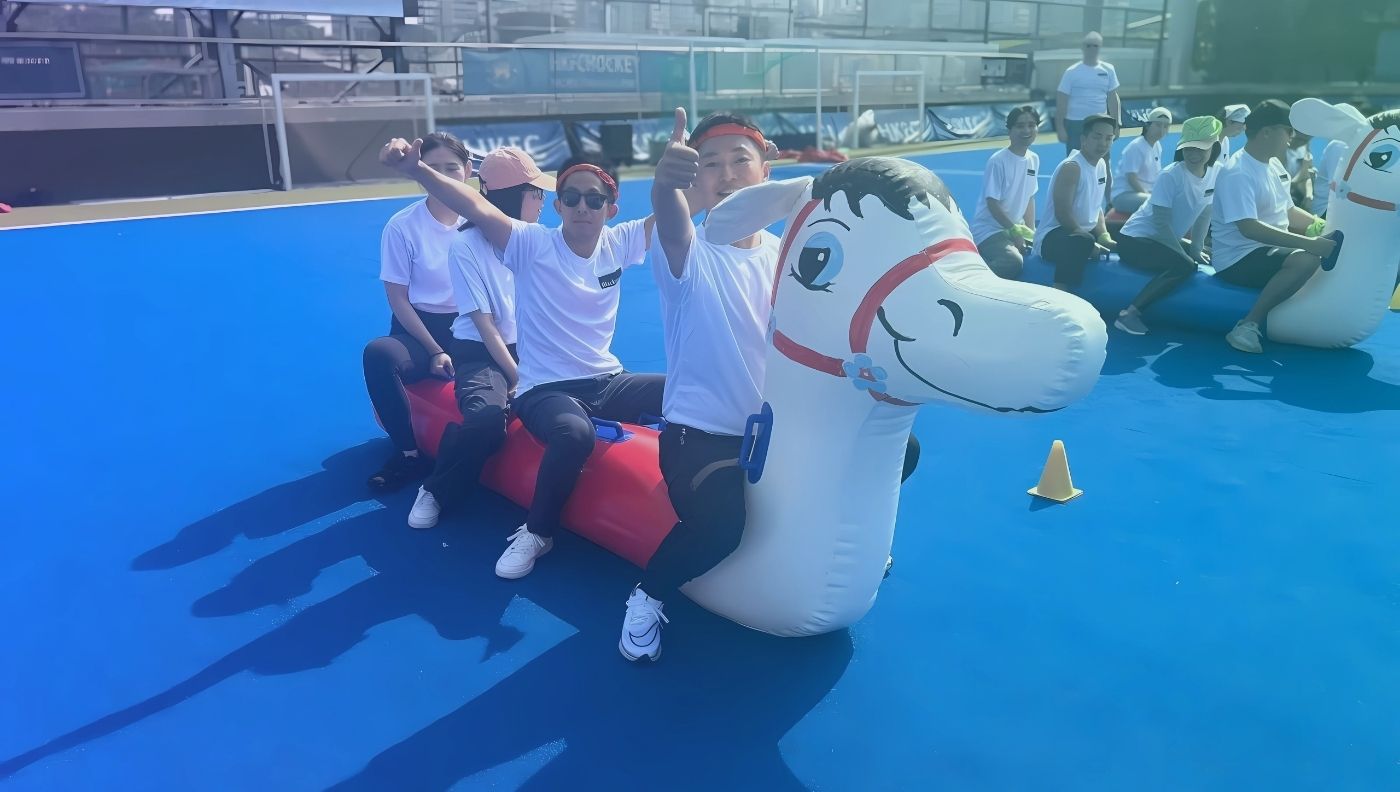 Participants hop on the inflatable horse, navigating challenges together and testing their skills and precision.